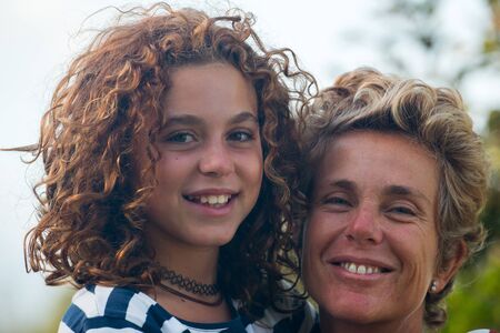 mother with her preteen girl in affectionate positionの写真素材