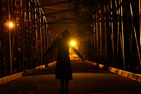 silhouette of dark girl on a bridgeの写真素材