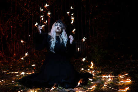 portrait of blonde girl in the dark with flashes of light around herの写真素材