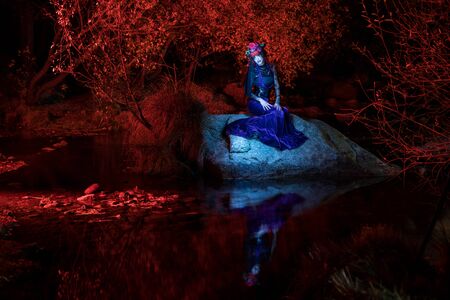 Model posing at night and illuminated only with flashlights by means of the technique of the painting of light.の写真素材
