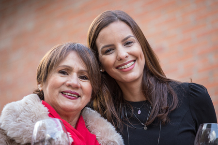 Mother and daughter pose happily on the terrace of their home