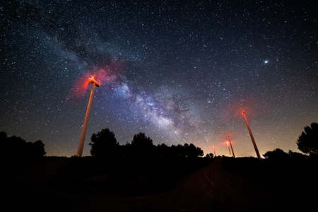 Long exposure night photography with the Milky Way and its galactic center on a wind power millの写真素材