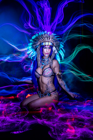 Woman dressed as an Indian poses as a model amidst long exposure lightsの写真素材