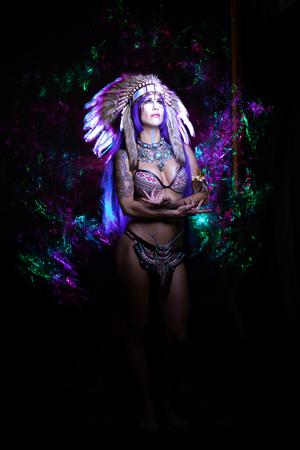 Woman dressed as an Indian poses as a model amidst long exposure lightsの写真素材
