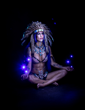 Woman dressed as an Indian poses as a model amidst long exposure lightsの写真素材