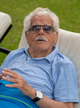 Great-grandfather, 100 years old, is relaxed in the garden of his home.の写真素材