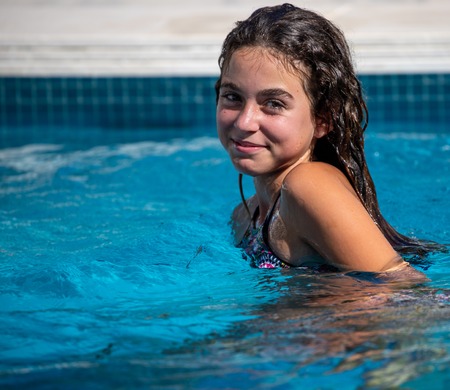 Photograph of a girl in the swimming pool of her houseの写真素材