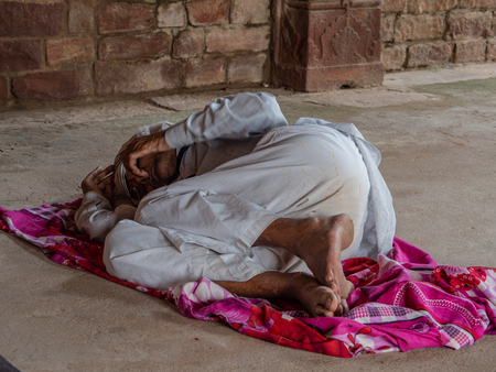 Jaipur, India, 18th to 22nd September 2018 Homeless man sleeps in the middle of the street covered by the roof of a houseのeditorial素材