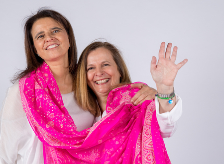 Photo shoot of two friends posing with pink foulard and affectionate attitude.の写真素材