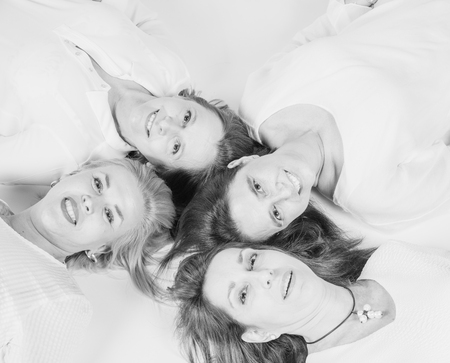Photographic session in a studio to four friends lying on the floor with white background.の写真素材