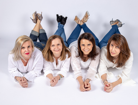 Photographic session in a studio to four friends lying on the floor with white background.の写真素材