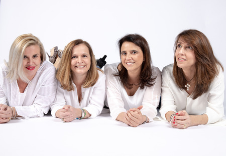 Photographic session in a studio to four friends lying on the floor with white background.の写真素材