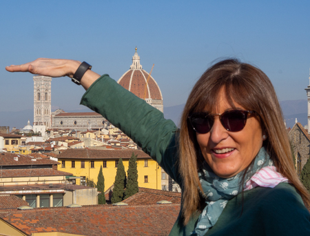 Mature and beautiful woman poses on a terrace and in front of the florentine cathedral, Santa Maria del Fiore y Ponte Vechioの写真素材