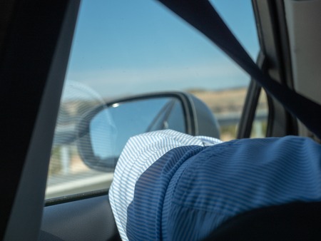 Arm driving and peeking out the window of the carの写真素材