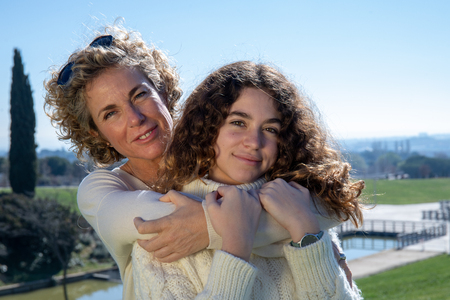 Mother and daughter embrace each other with the blue skyの写真素材