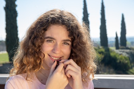 Portrait of a pre-adolescent girl posing in a public park on a sunny spring dayの写真素材