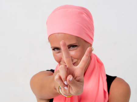 Young girl with pink handkerchief on her head and whiteの写真素材