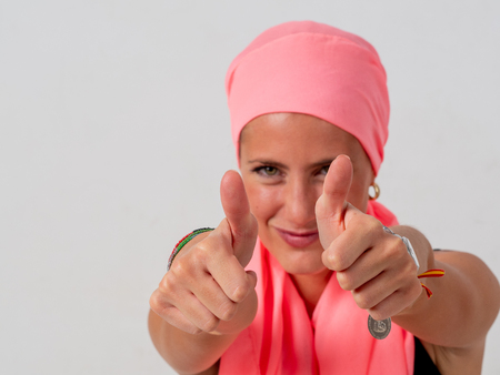 Young girl with pink handkerchief on her head and whiteの写真素材