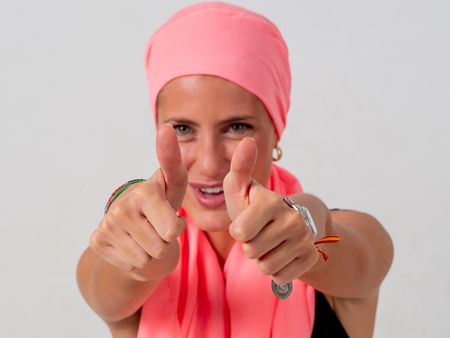 Young girl with pink handkerchief on her head and whiteの写真素材