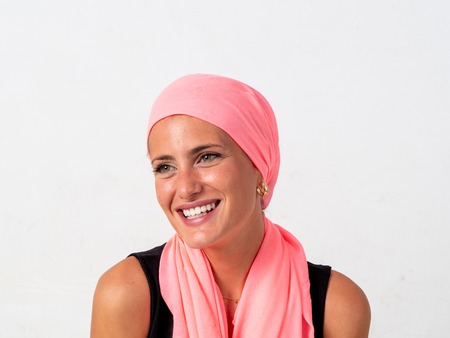Young girl with pink handkerchief on her head and whiteの写真素材