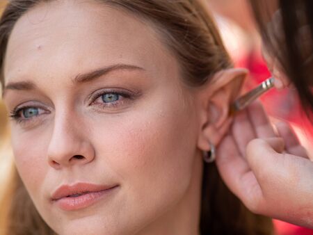 Makeup on the ears to a model to turn her into an elf