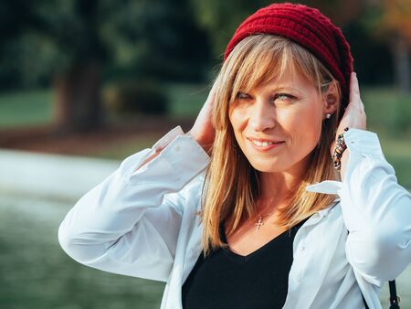 Portrait of Caucasian girl with blue eyes and red cap with sunset light