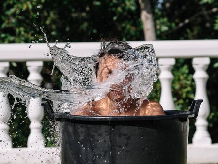 High-speed photograph that captures the impact of water by hitting the face of a teenage boy inside...