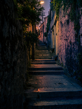 Stock vertical photo of a narrow alley at night in the city of Dubrovnik, a walled city