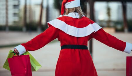 stock photo of mama noel with skates holding a lantern with gift bags in hand. Christmas timeの写真素材