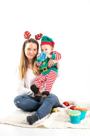 Stock studio photo with white background of a mother and a baby disguised with Christmas elements.の写真素材