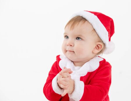 Stock studio photo with a white background of a baby dressed as Santa Claus shaking handsの写真素材
