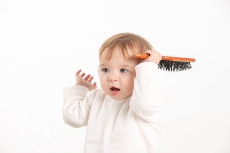 Stock studio photo with a white background of a baby playing with a combの写真素材