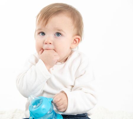 Stock studio photo with a white background of a baby with a canteen with handlesの写真素材