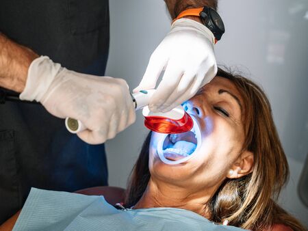 Caucasian Patient Goes To Dentist's Office For Teeth Whiteningの写真素材