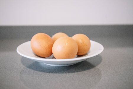 Close-up of a plate with four raw chicken eggsの写真素材