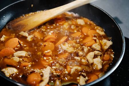 Close-up photograph of a pan cooking a rice and chicken paella in Spain during confinementの写真素材