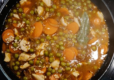 Top view of a pan cooking a rice and chicken paella in Spain during confinementの写真素材