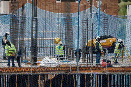 April, 15 2020, in Madrid, Spain some colleagues from the construction industry are working together on the construction of a buildingのeditorial素材