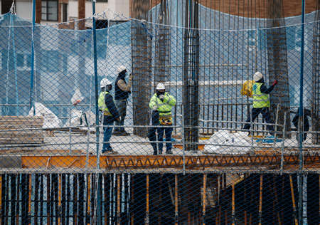 April, 15 2020, in Madrid, Spain a group of workers working in construction with masks during the covid-19 pandemicのeditorial素材