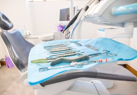Set of clean dental instruments placed on disposable napkin on table near chair in office in modern clinicの写真素材