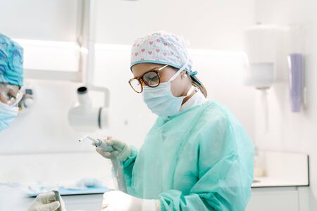 Dentist's assistant prepares a patient for an operationの写真素材