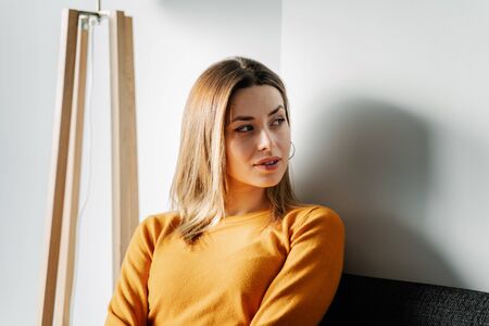 Young woman in an orange jersey waits in a clinicの写真素材