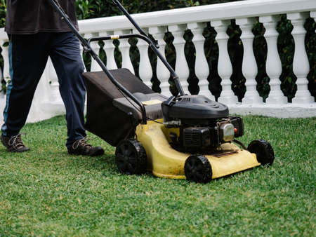 Old electric lawn mower working in the gardenの写真素材