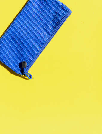 Photograph of a yellow background with blue case. Bright and vivid colorsの写真素材