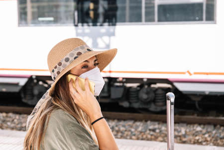 Crop female with pocket mirror pouting lips and applying rouge on cheek while sitting on passenger seat of vehicleの写真素材