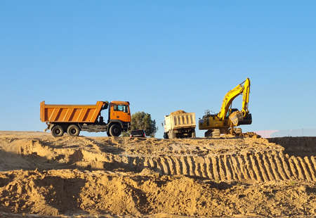Excavator loader with rised backhoe in a sky background. Digger working in Valdebebas, Madrid.の写真素材