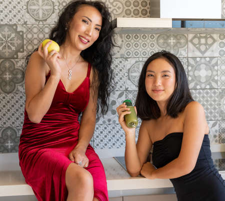 two elegant girls posing with a snack looking at the camera, horizontal portraitの写真素材