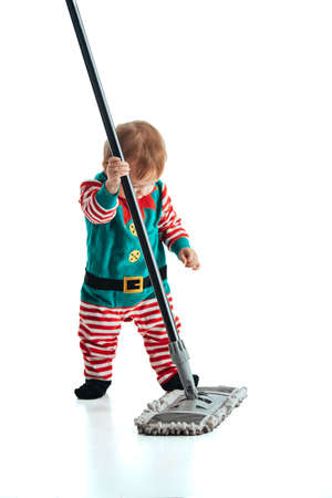 Stock studio photo with white background of a baby disguised as an elf with a mopの写真素材