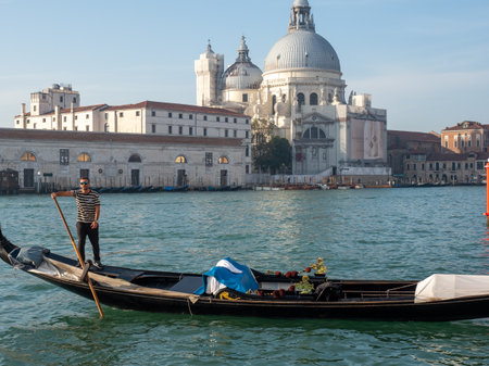 October 31, 2022 - Venice, Italy: Gondolier standing on a gondola in the grand canal. Tourism concept.の写真素材