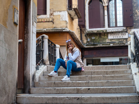 <p>Tourist woman posing on the stairs on a bridge in the city of Venice, Italy. Tourism concept.</p>の写真素材